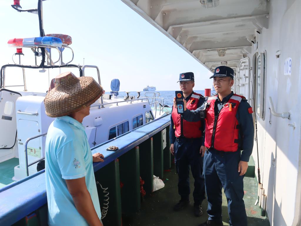 图为5月12日海警执法员登临检查渔船。